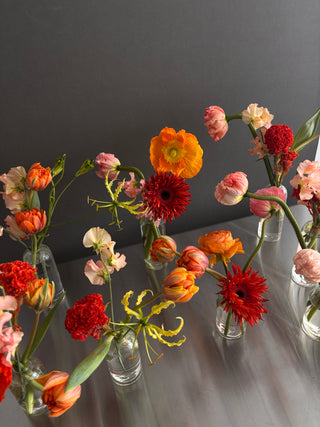 Yellow and orange flowers in clear bud vases