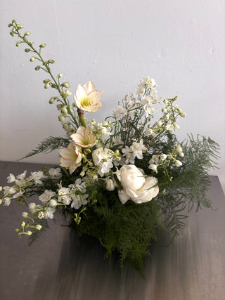 Bouquet of white flowers with greenery on a gray surface