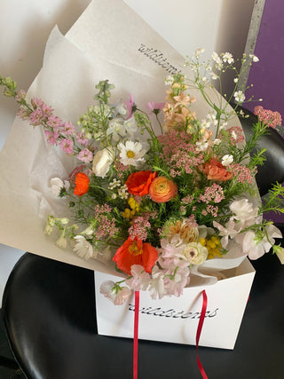 Bouquet of flowers with a white paper wrap on a black surface