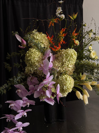 Floral arrangement with green and purple flowers on a black background