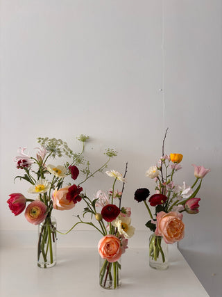 Clear glass bud vases with seasonal flowers