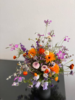 Floral arrangement in purple and orange flowers on a table
