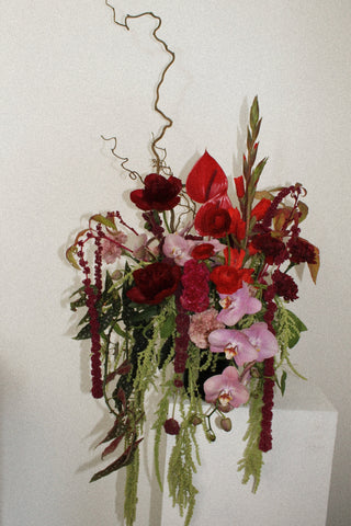 Floral arrangement with red, pink, and green flowers on a white background