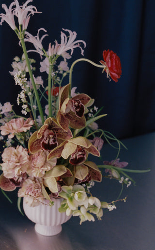 Floral arrangement in a white vase on a dark background