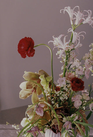 Bouquet of flowers with a red bloom against a neutral background