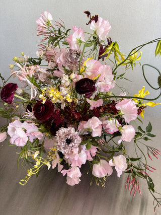 Bouquet of flowers with pink, purple, and yellow colors on a neutral background
