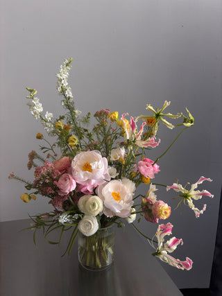 Bouquet of flowers in a clear vase on a gray background