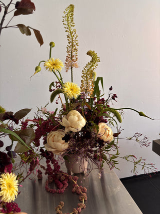 artful Floral arrangement with yellow and white flowers on a plain background