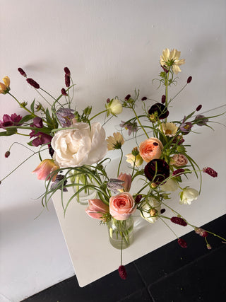Floral arrangement with pink and white flowers on a white surface