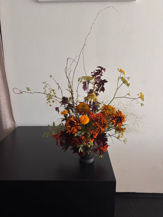 Bouquet of autumn flowers on a white surface with a black background