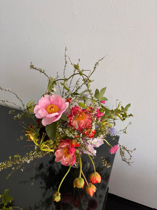 Bouquet of colorful flowers on a dark surface with a light gray background